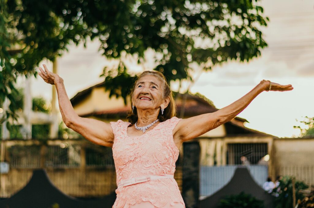 Senior woman joyfully stretching outdoors to start living your healthiest life with positivity and wellness